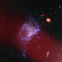 Псевдоцветное изображение, включающее данные инфракрасного диапазона (невидимого человеческим глазом). Синие области (Объект Минковского) отвечают за процесс звездообразования. Красная фоновая галактика и две красные звезды на переднем плане с этими областями находятся в явном контрасте. Размытая красная полоса сверху - радиоджет. Галактика NGC 541. Фото с сайта www.llnl.gov